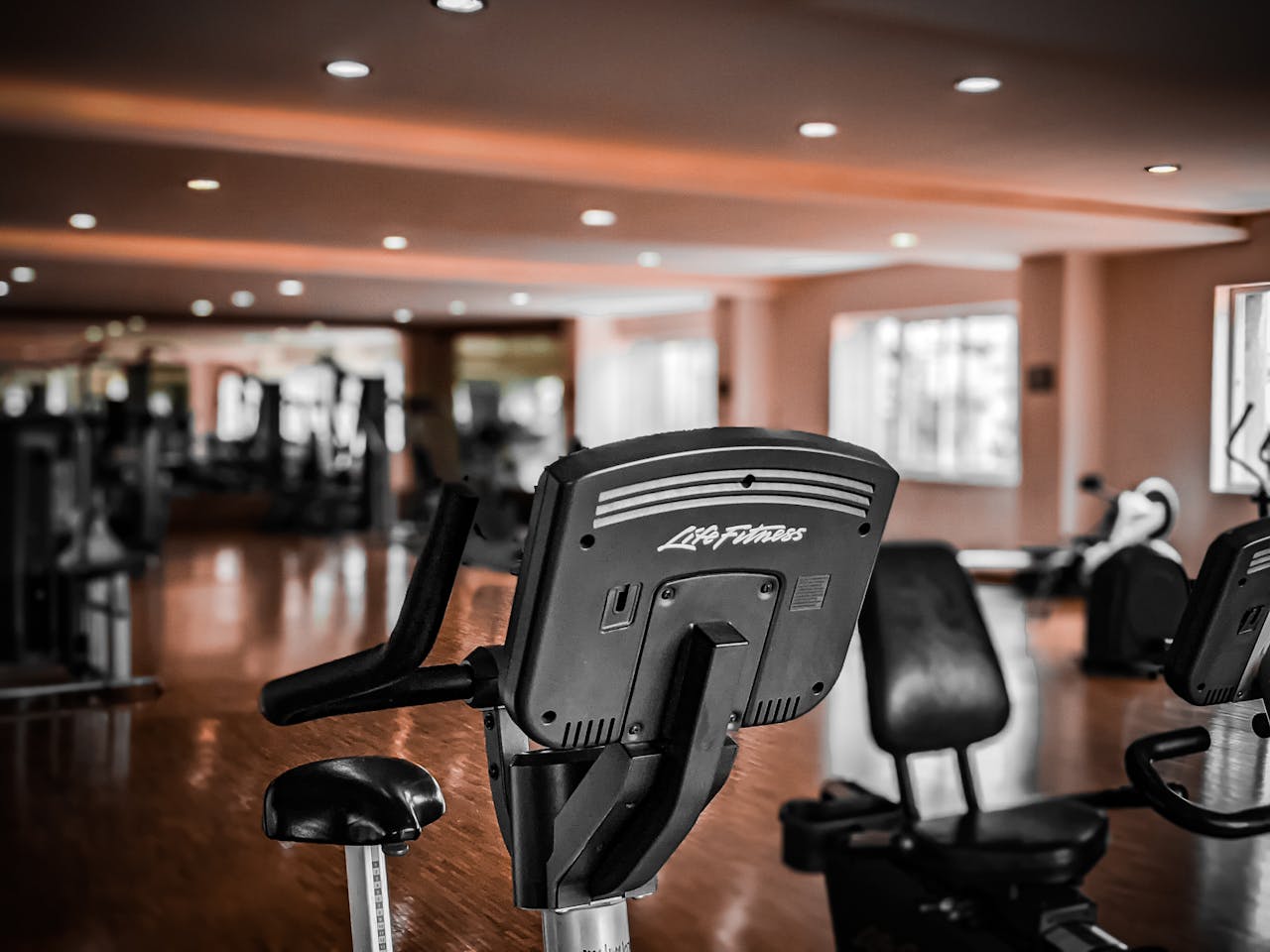 hero-img-01 A modern gym interior featuring stationary exercise bikes and equipment for fitness enthusiasts.